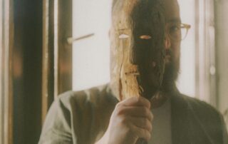 Homem segurando uma máscara, simbolizando a sociopatia e o comportamento sociopata em relações sociais